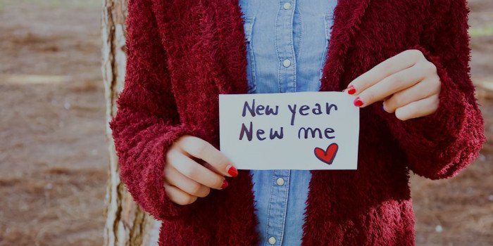En person som håller upp en lapp med texten New year New me