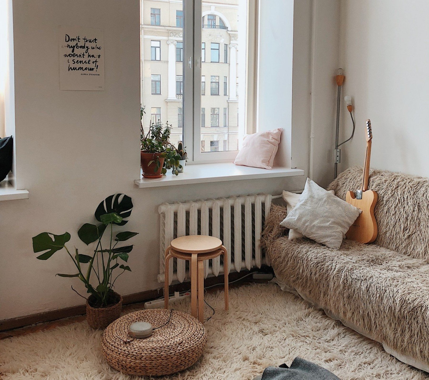 Bild inuti en lägenhet med soffa, gitarr och pallar