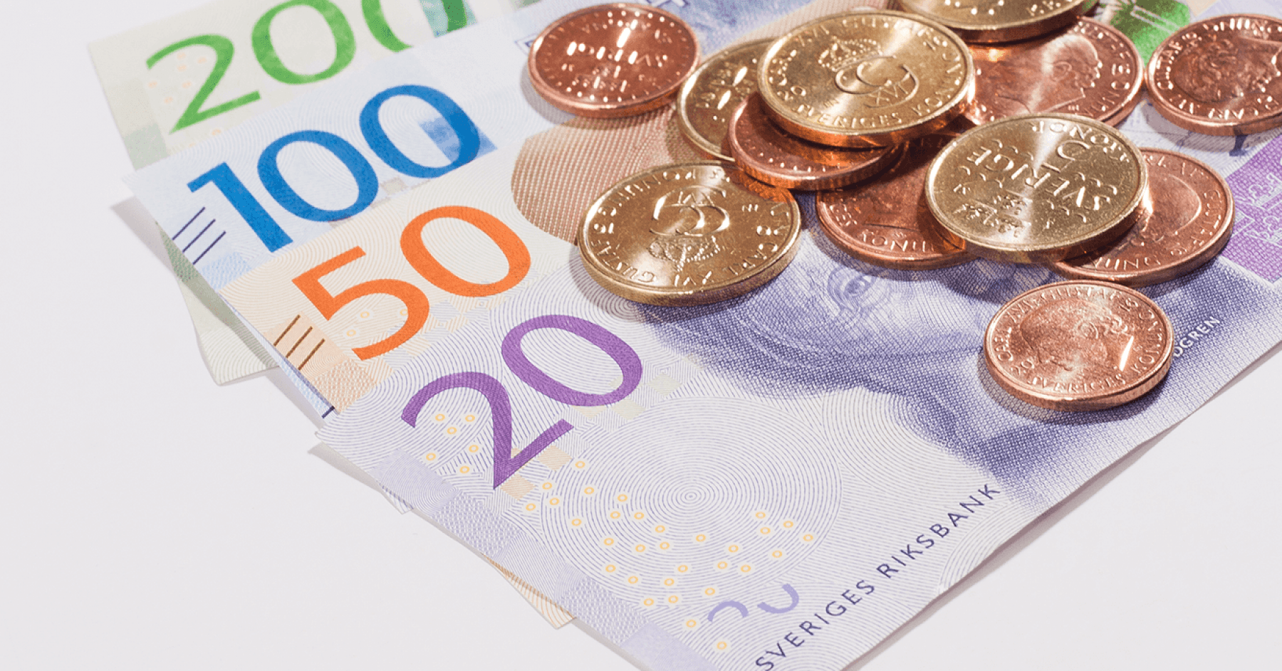 Svenska sedlar och mynt ligger på ett bord