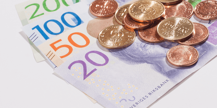 Svenska sedlar och mynt ligger på ett bord