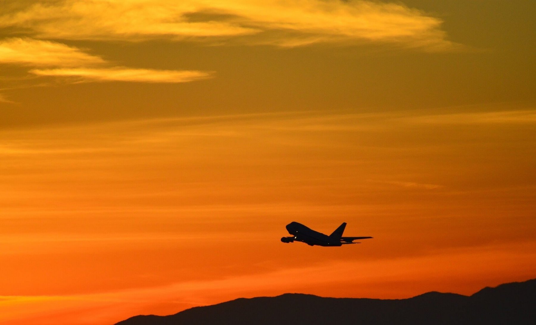 Flygplan som flyger över solnedgång