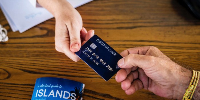 En man och en kvinna håller ett kreditkort i var sitt hörn.