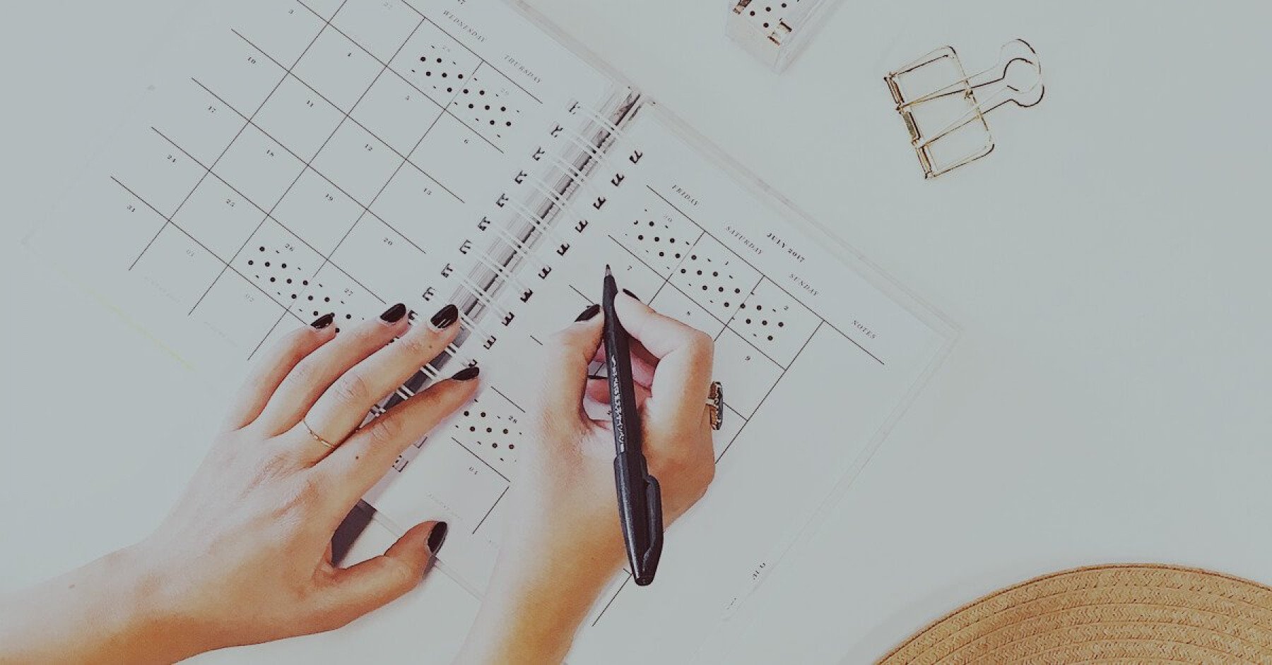 Händer som skriver i en kalender.